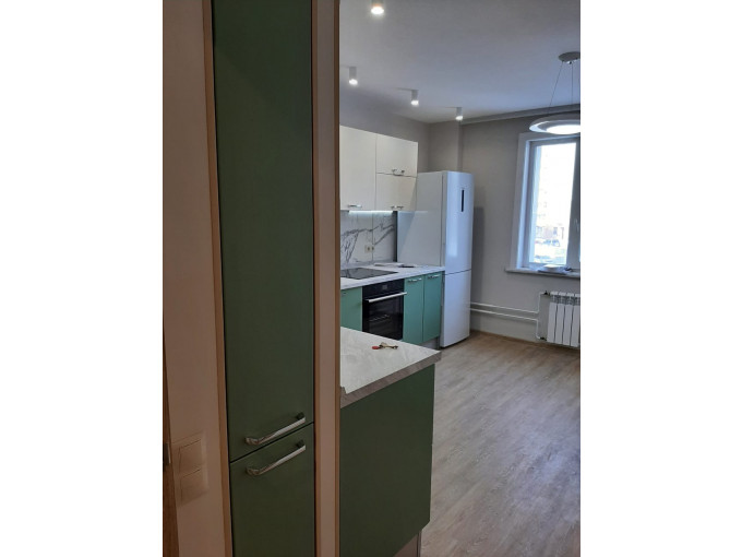 Угловая современная кухня с зелеными фасадами для молодой семьи в новую квартиру - фото - 2