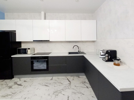 Угловая современная кухня в бело-сером цвете с просторной рабочей зоной - фото - 1