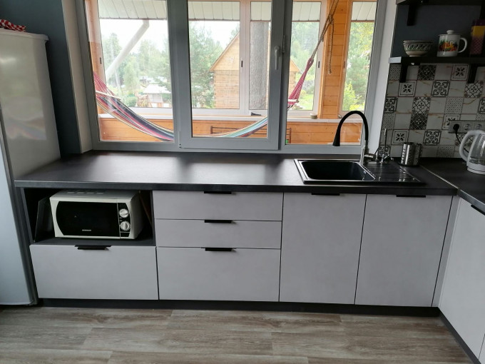 Современная угловая кухня без верхних навесных шкафов в загородный дом - фото - 4