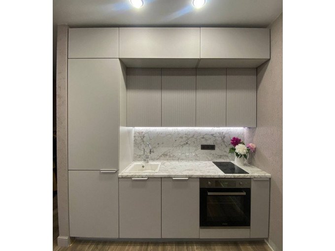 Белая встроенная кухня с антресолями и рифлеными фасадами - фото - 1